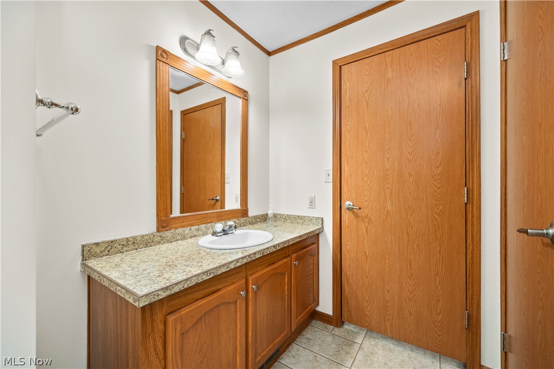 35157 Center Ridge Road, Unit 92 North Ridgeville, OH 44039 - Photo 17 of 40 Vanity with wood-finish cabinetry, integrated sink, and granite-look countertop