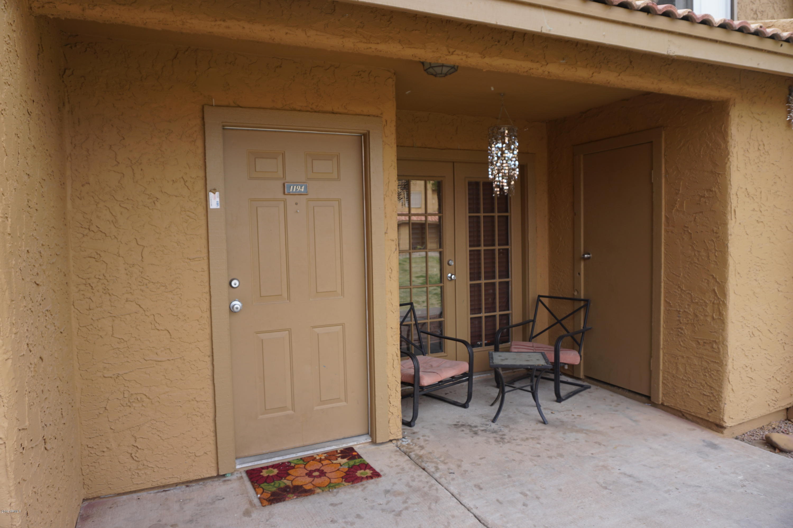 3511 East Baseline Road, Unit 1194 Phoenix, AZ 85042 - Photo 11 of 12 a view of a hallway with chairs and a potted plant in front of door