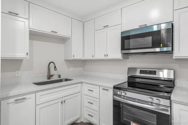 a kitchen with white cabinets and stainless steel appliances