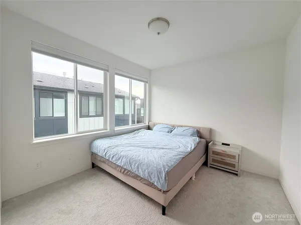 a bed sitting in a bedroom next to a window