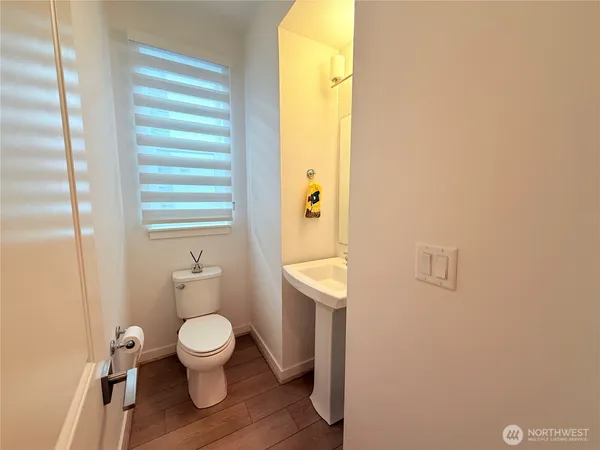 a white toilet sitting next to a bathroom sink and a window