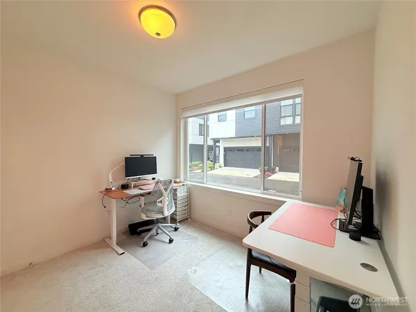 a view of a workspace with furniture and a window