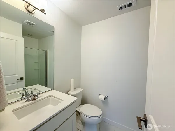 a bathroom with a sink mirror and toilet