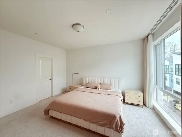 a bedroom with a bed and a large window