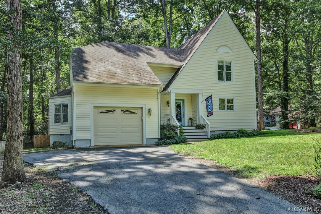5612 Woods Walk Road Midlothian, VA 23112 - Photo 2 of 26 a front view of a house with a yard and garage