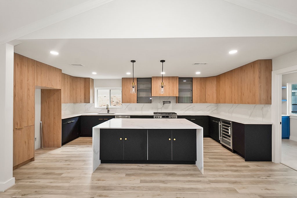 6106 Rutherglenn Drive Houston, TX 77096 - Photo 13 of 41 Beautifully redesigned kitchen featuring a massive waterfall island, quartz countertops, and sleek cabinetry.