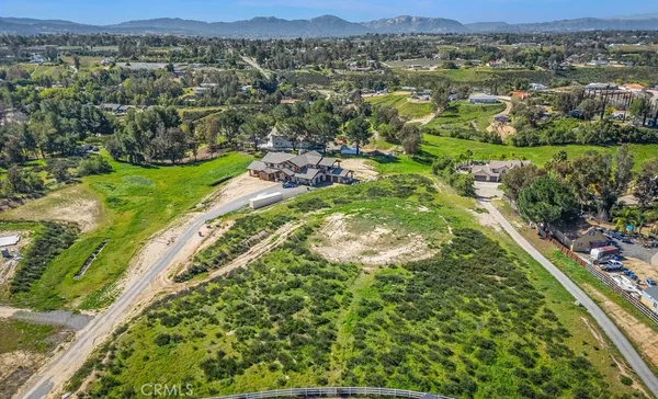 an aerial view of residential houses with outdoor space and trees