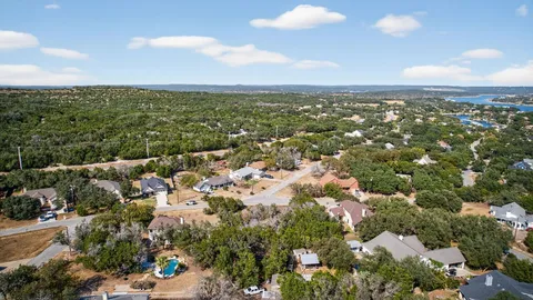 an aerial view of residential houses with outdoor space and trees
