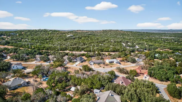 an aerial view of residential houses with outdoor space and trees