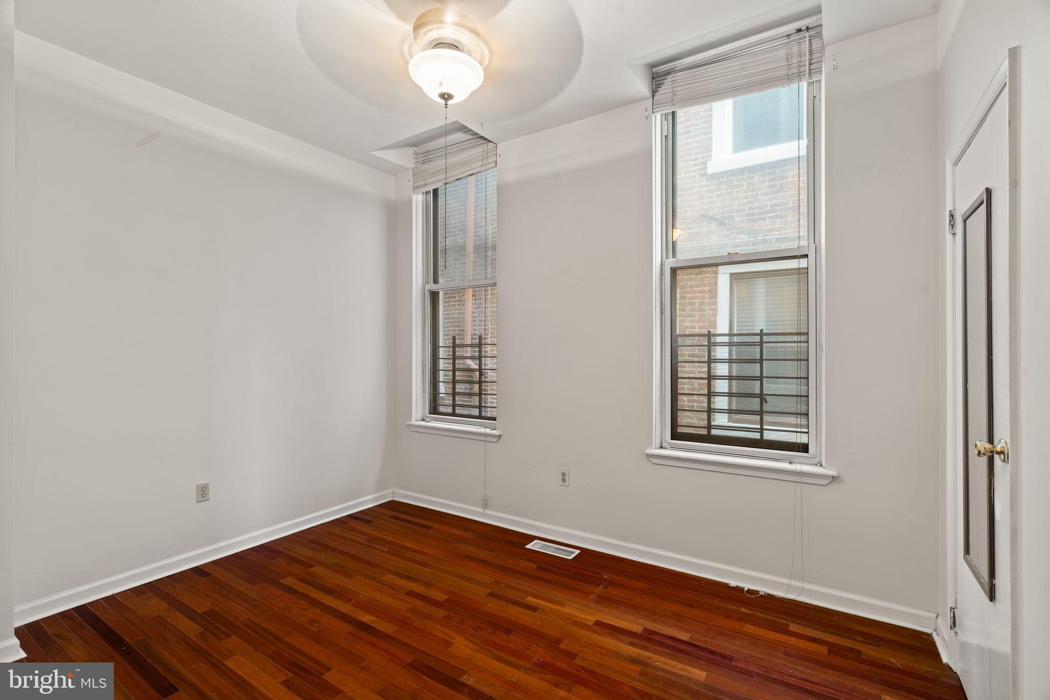 1828-00 Green Street, Unit 1R Philadelphia, PA 19130 - Photo 15 of 37 a view of an empty room with wooden floor and a window