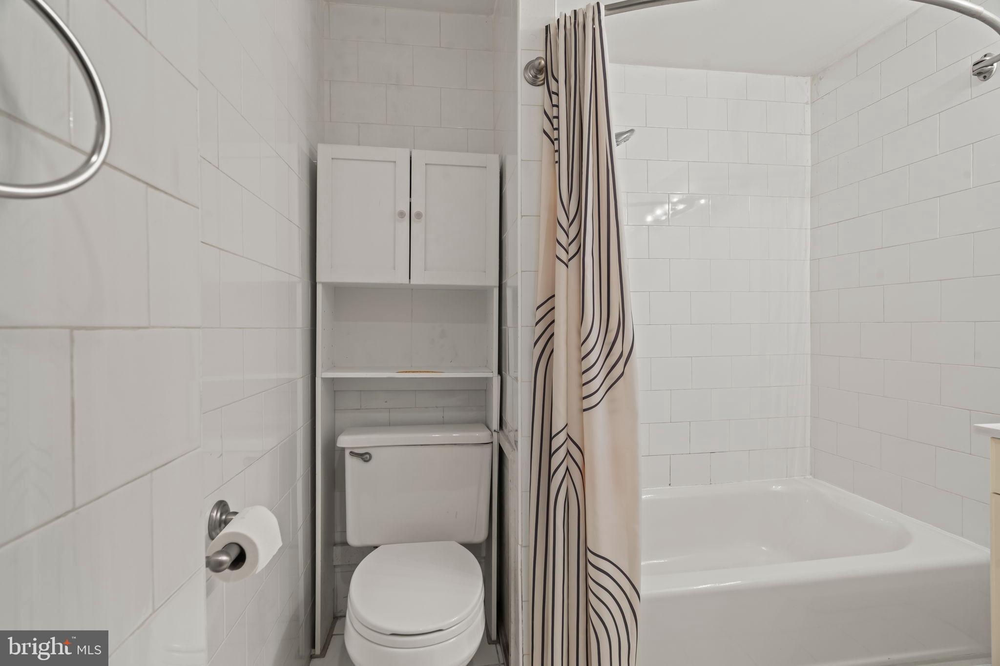 1828-00 Green Street, Unit 1R Philadelphia, PA 19130 - Photo 18 of 37 a bathroom with a granite countertop bathtub shower and toilet