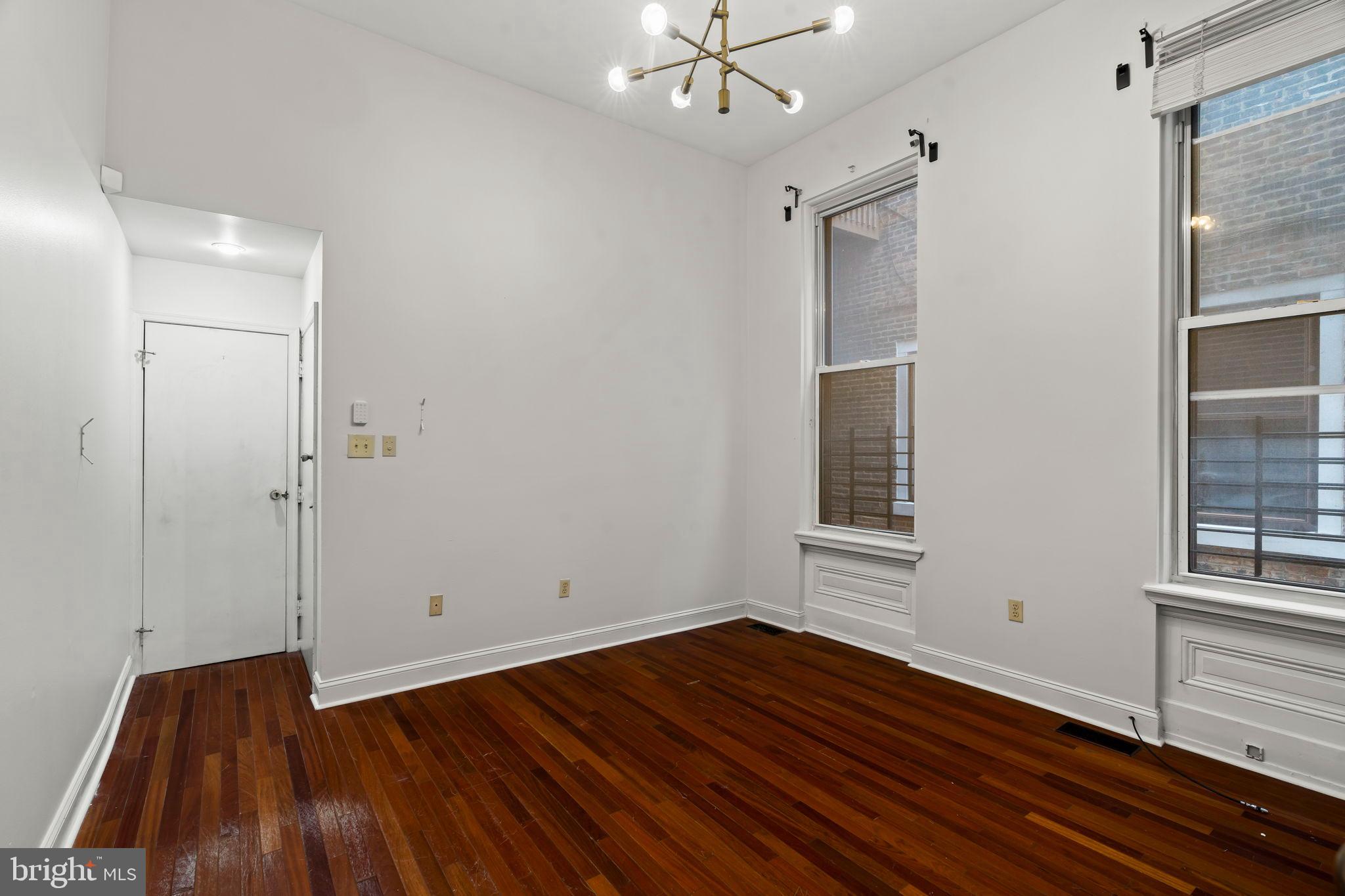 1828-00 Green Street, Unit 1R Philadelphia, PA 19130 - Photo 8 of 37 an empty room with wooden floor and windows