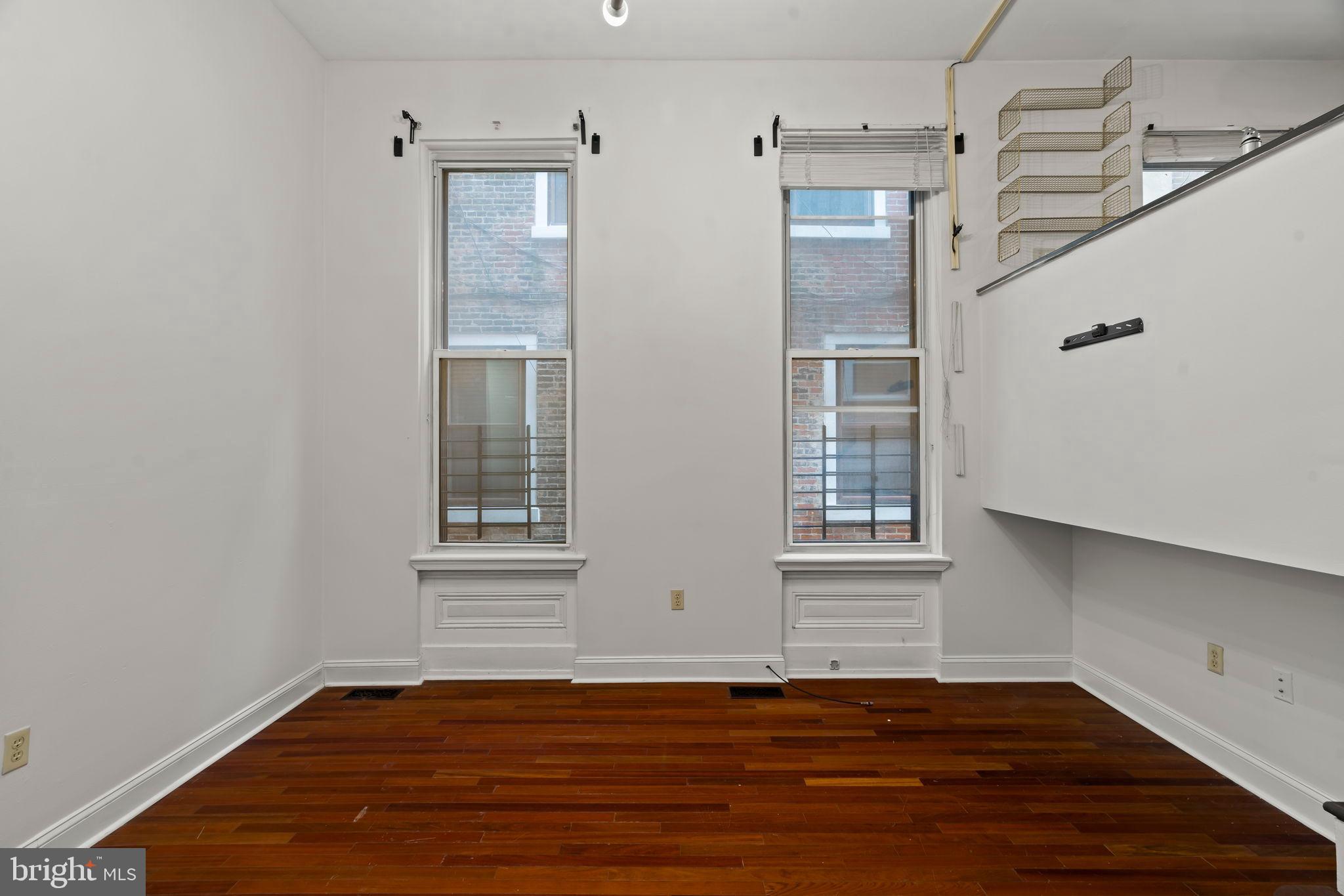 1828-00 Green Street, Unit 1R Philadelphia, PA 19130 - Photo 9 of 37 a view of an empty room with wooden floor and a window