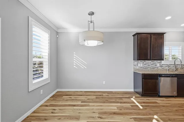 a view of an empty room with window and wooden floor