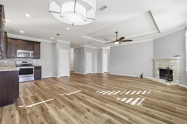 a view of a livingroom with a fireplace a sink and a ceiling fan