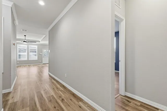 a view of a hallway with wooden floor