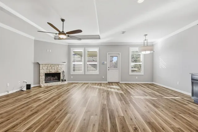 a view of empty room with fireplace and wooden floor