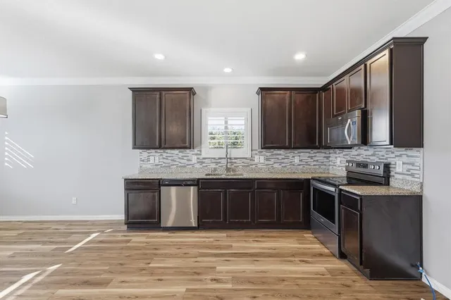 a large kitchen with granite countertop a sink and a stove top oven