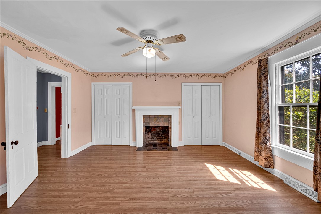 245 Cromer Road Williamston, SC 29697 - Photo 9 of 27 This inviting room features warm wood flooring and a charming fireplace, offering comfort and style.