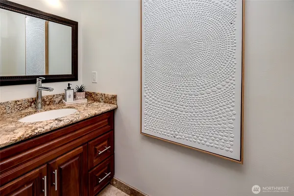 a bathroom with a granite countertop sink and a mirror