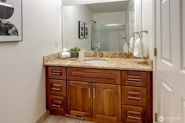 a bathroom with a granite countertop sink and a mirror