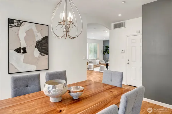 a dining room with wooden floor table and chairs