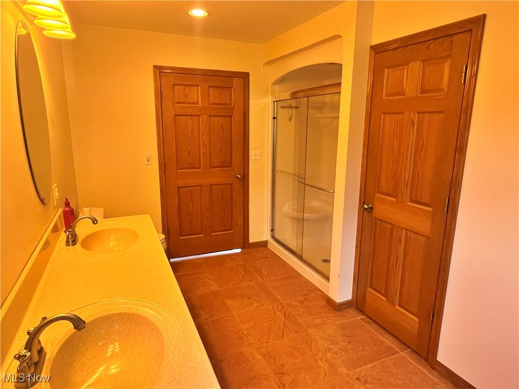 17583 Davis Ridge Road Caldwell, OH 43724 - Photo 23 of 42 Full bath featuring a shower stall, double vanity, recessed lighting, and light tile patterned floors