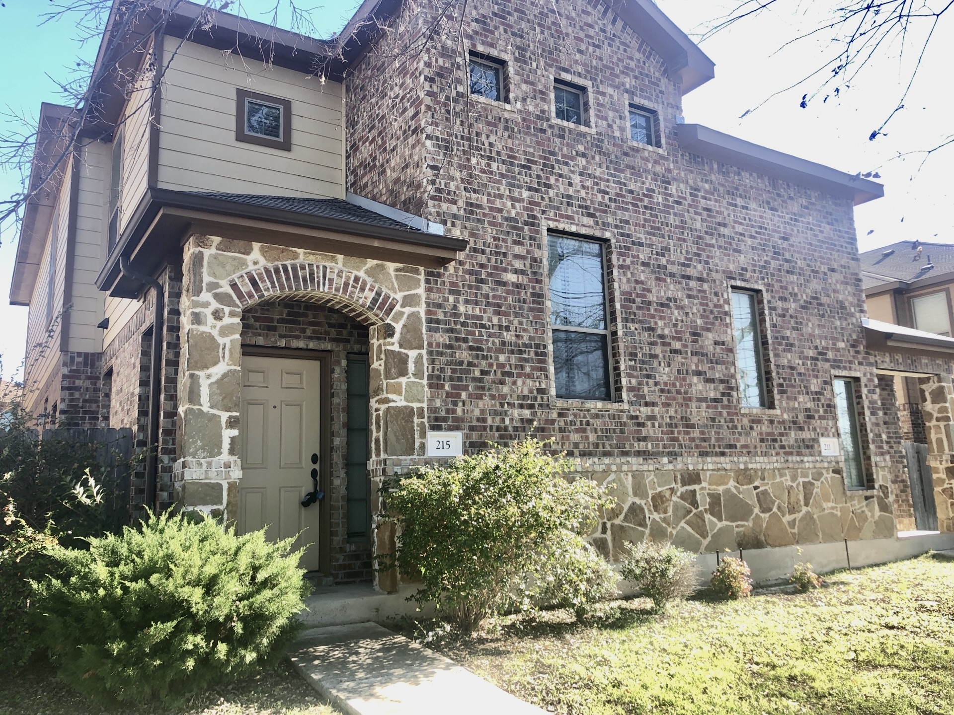 215 North College Street Georgetown, TX 78626 - Photo 1 of 1 The property features a stone and brick facade, with a covered entryway and a light-colored front door