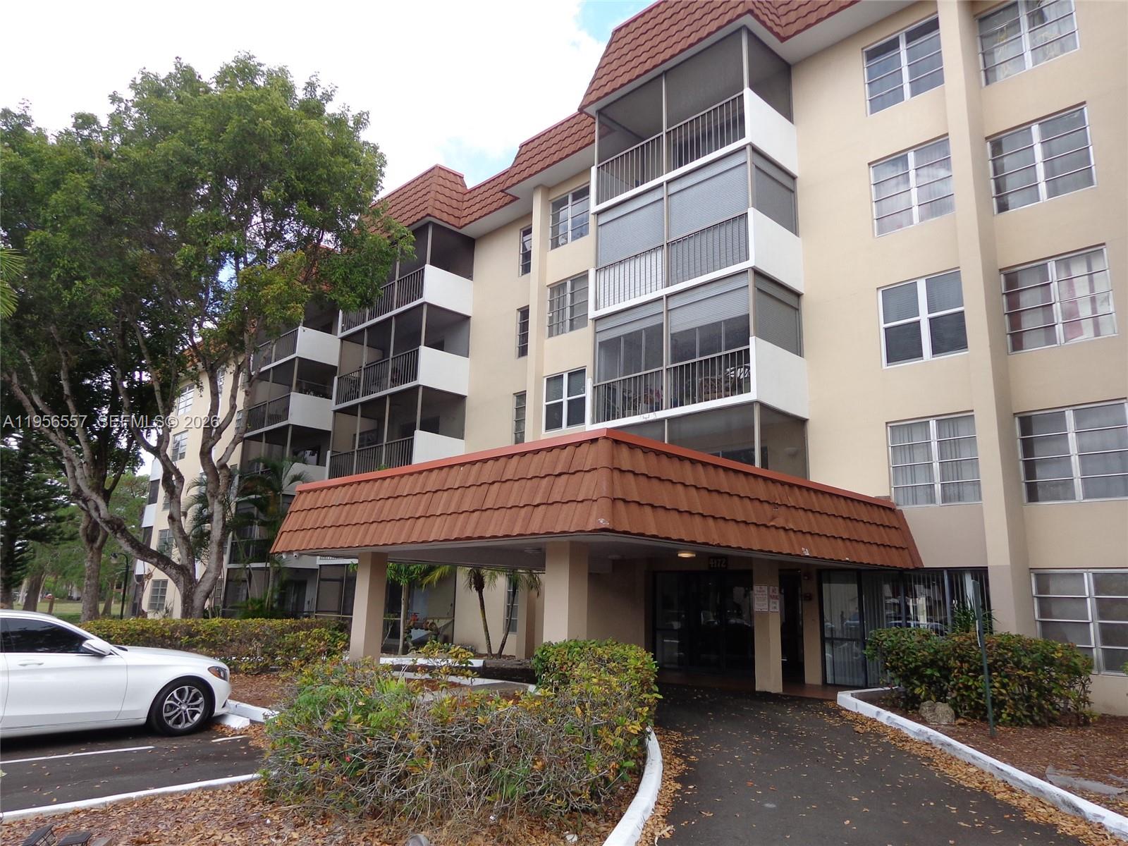 a front view of a building and car parked