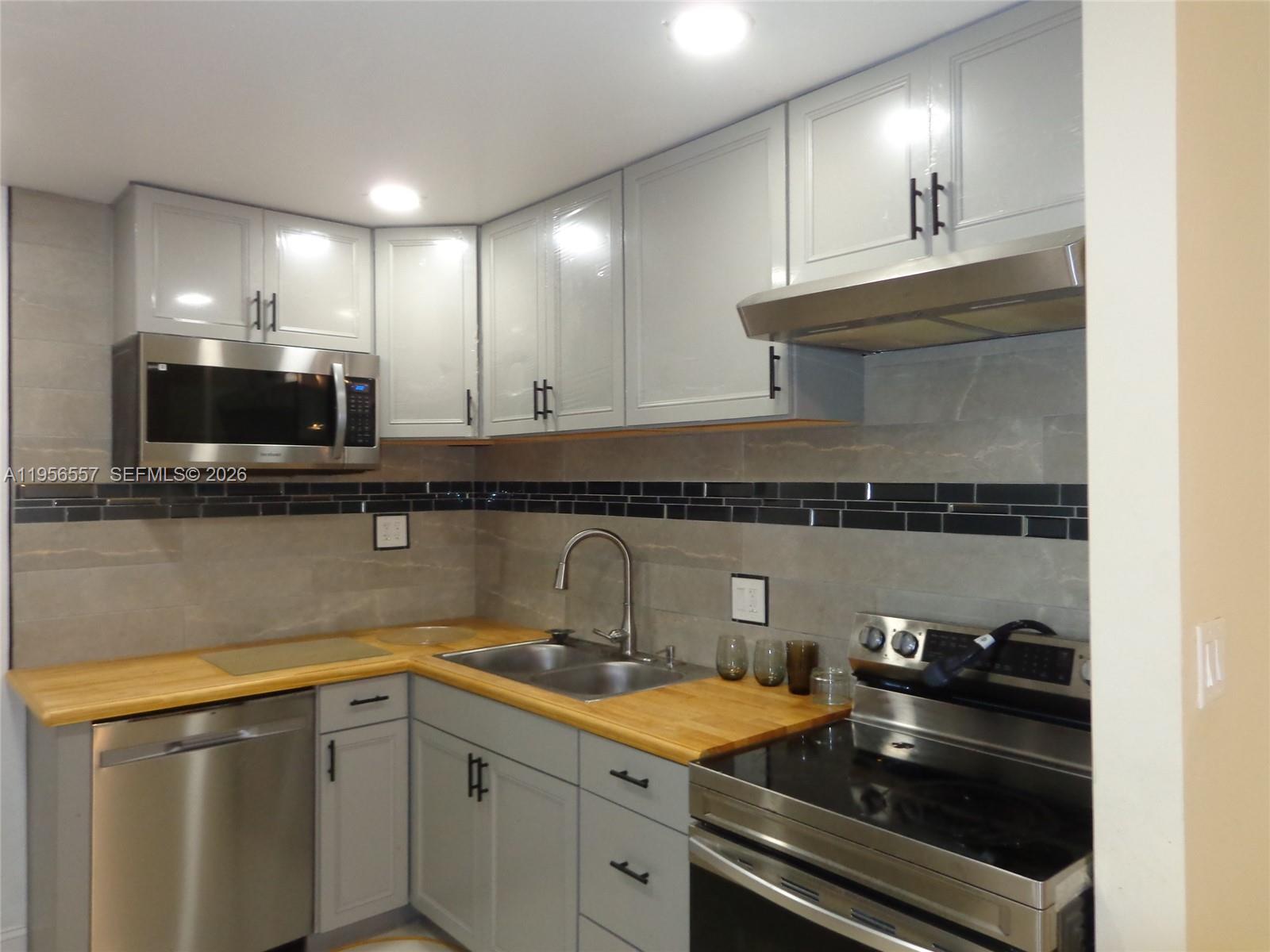 4172 Inverrary Drive, Unit 110 Lauderhill, FL 33319 - Photo 2 of 25 a kitchen with granite countertop a sink stainless steel appliances and cabinets