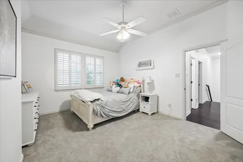 a spacious bedroom with a bed and a chandelier