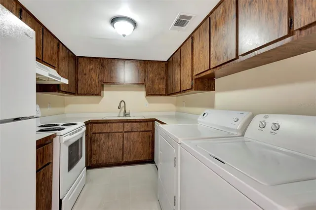 a kitchen with a sink a stove and cabinets