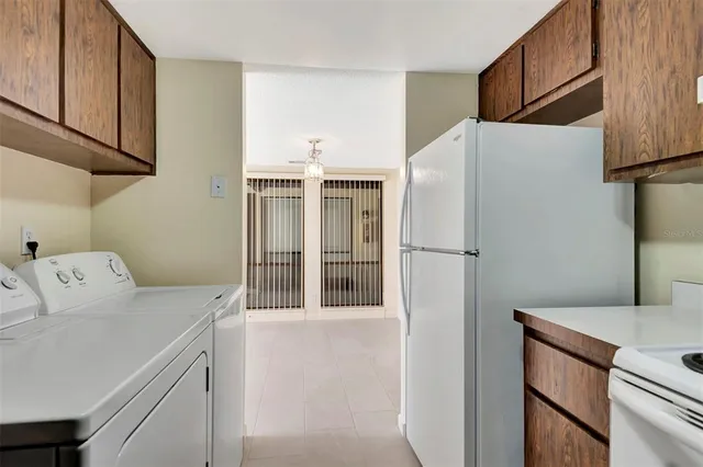 a white refrigerator freezer and a stove sitting inside of a kitchen