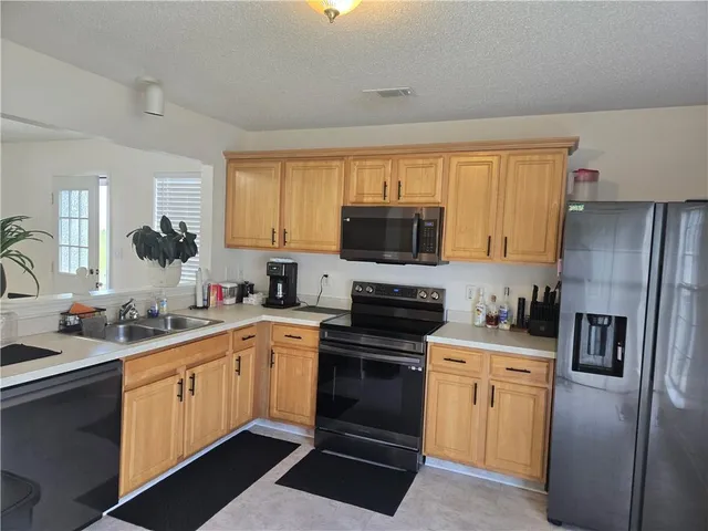 a kitchen with a sink appliances and cabinets