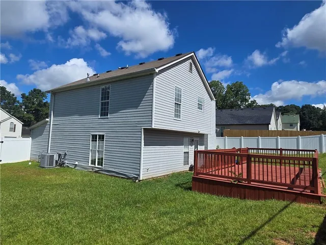 a view of a house with a yard and deck