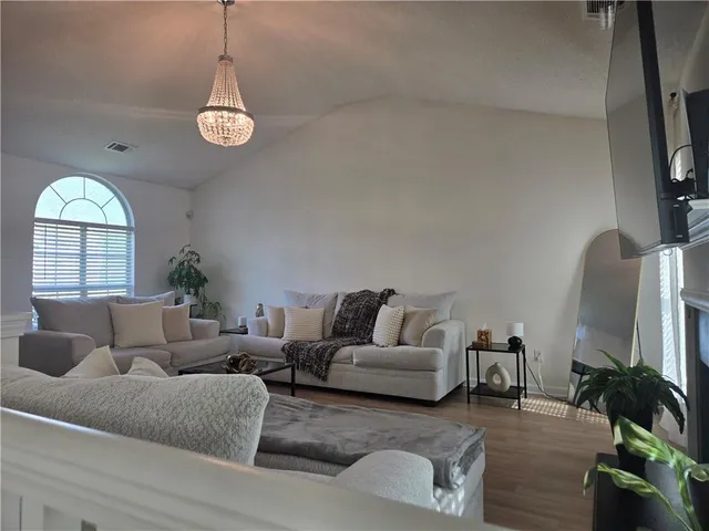 a living room with furniture a fireplace and a flat screen tv