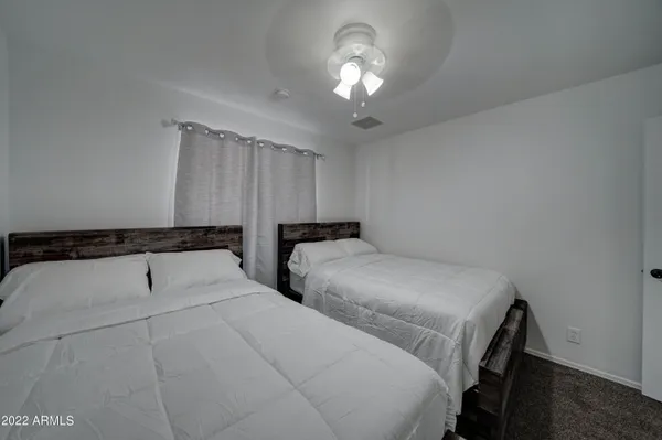 a bedroom with two beds and a chandelier