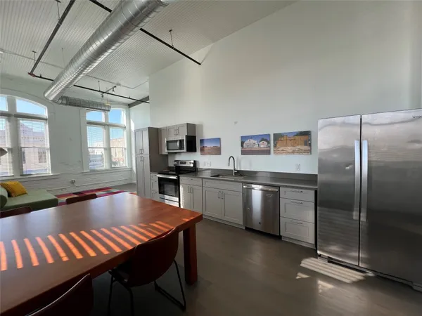 a kitchen with stainless steel appliances granite countertop a sink a stove and refrigerator