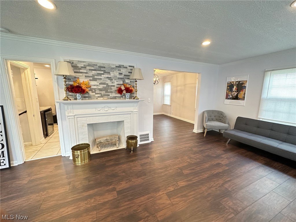 3688 Rolliston Road Cleveland, OH 44120 - Photo 4 of 44 Living room with ornamental molding, a textured ceiling, a fireplace, and tile flooring