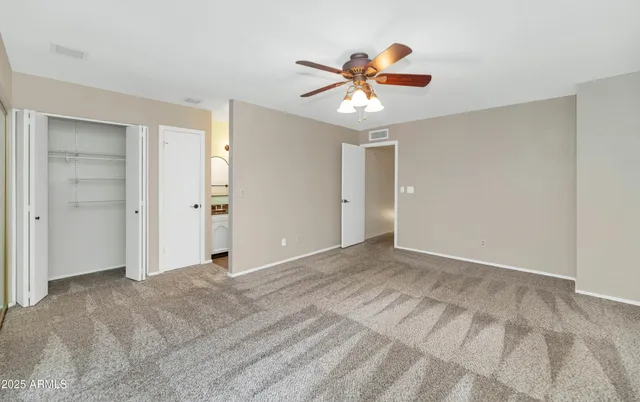 a view of an empty room with window and closet area