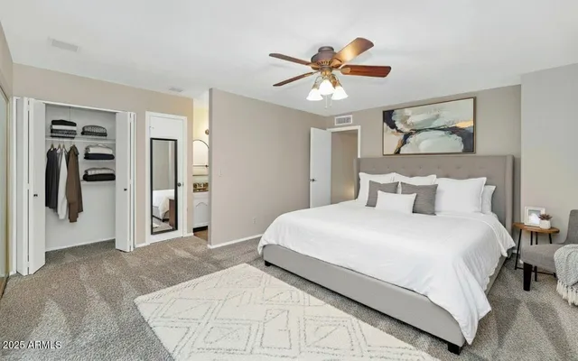 a bedroom with a large bed and a chandelier