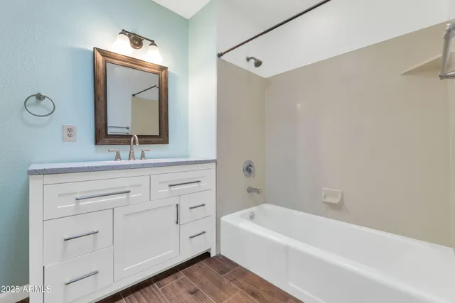 a bathroom with a bathtub sink and mirror