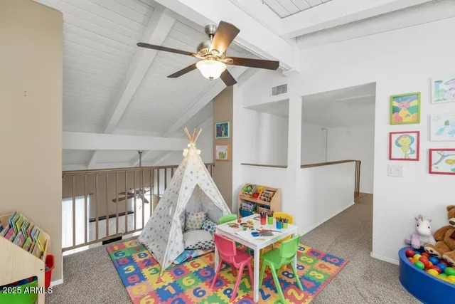 a bedroom with furniture a baby crib lounge chair and a chandelier