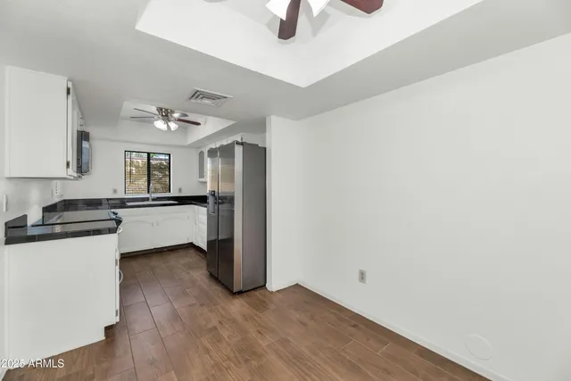 a kitchen with granite countertop a sink cabinets and stainless steel appliances