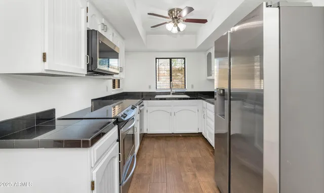 a kitchen with stainless steel appliances granite countertop a sink a stove and a refrigerator