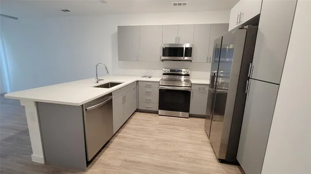 a kitchen with kitchen island a sink appliances and cabinets