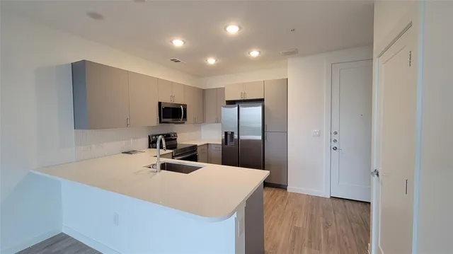 a view of a kitchen with a sink and wooden floor