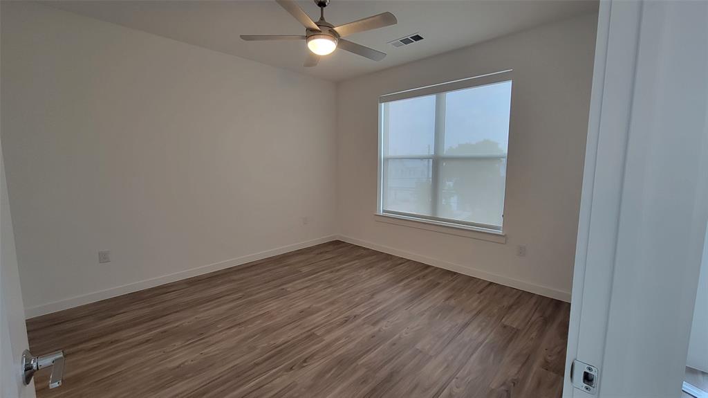 4801 Springdale Road, Unit 1202 Austin, TX 78723 - Photo 7 of 15 an empty room with wooden floor fan and windows
