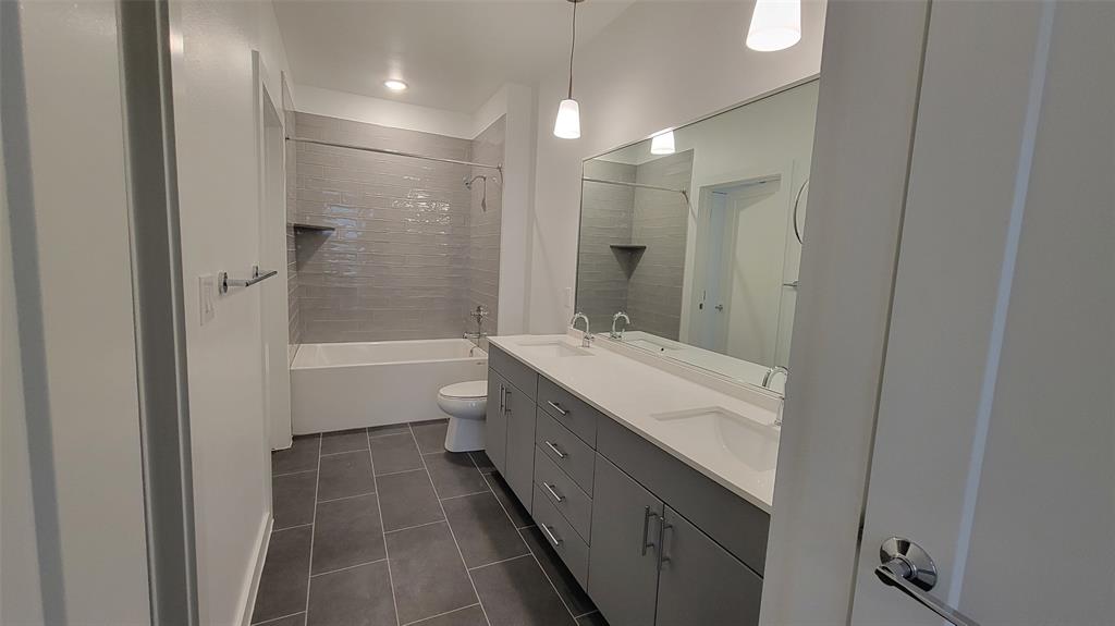 4801 Springdale Road, Unit 1202 Austin, TX 78723 - Photo 8 of 15 a bathroom with a granite countertop sink a toilet and shower