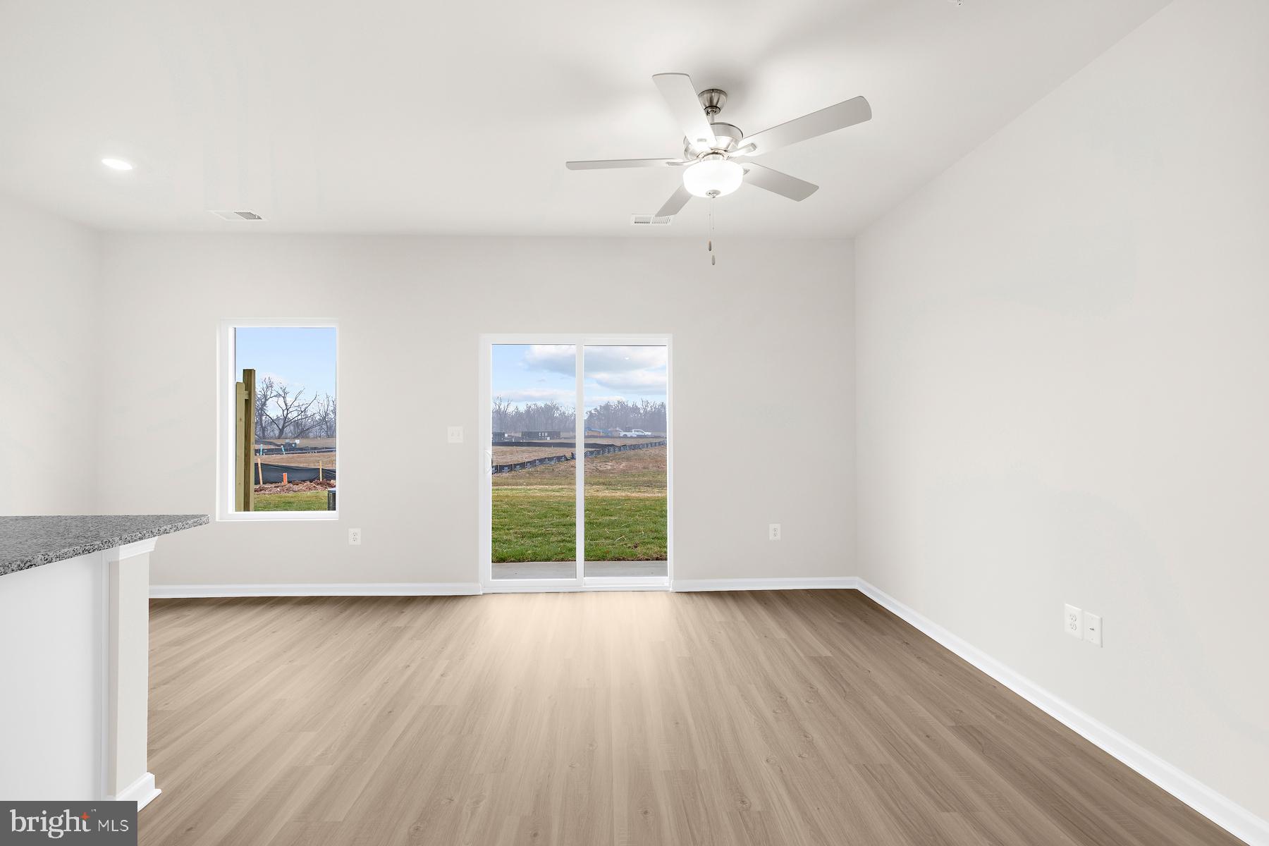 8155 Bartholomew Court Baltimore, MD 21206 - Photo 13 of 19 an empty room with wooden floor chandelier fan and windows
